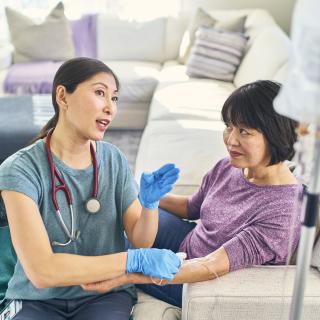 A nurse speaks with a patient during the at-home infusion process.