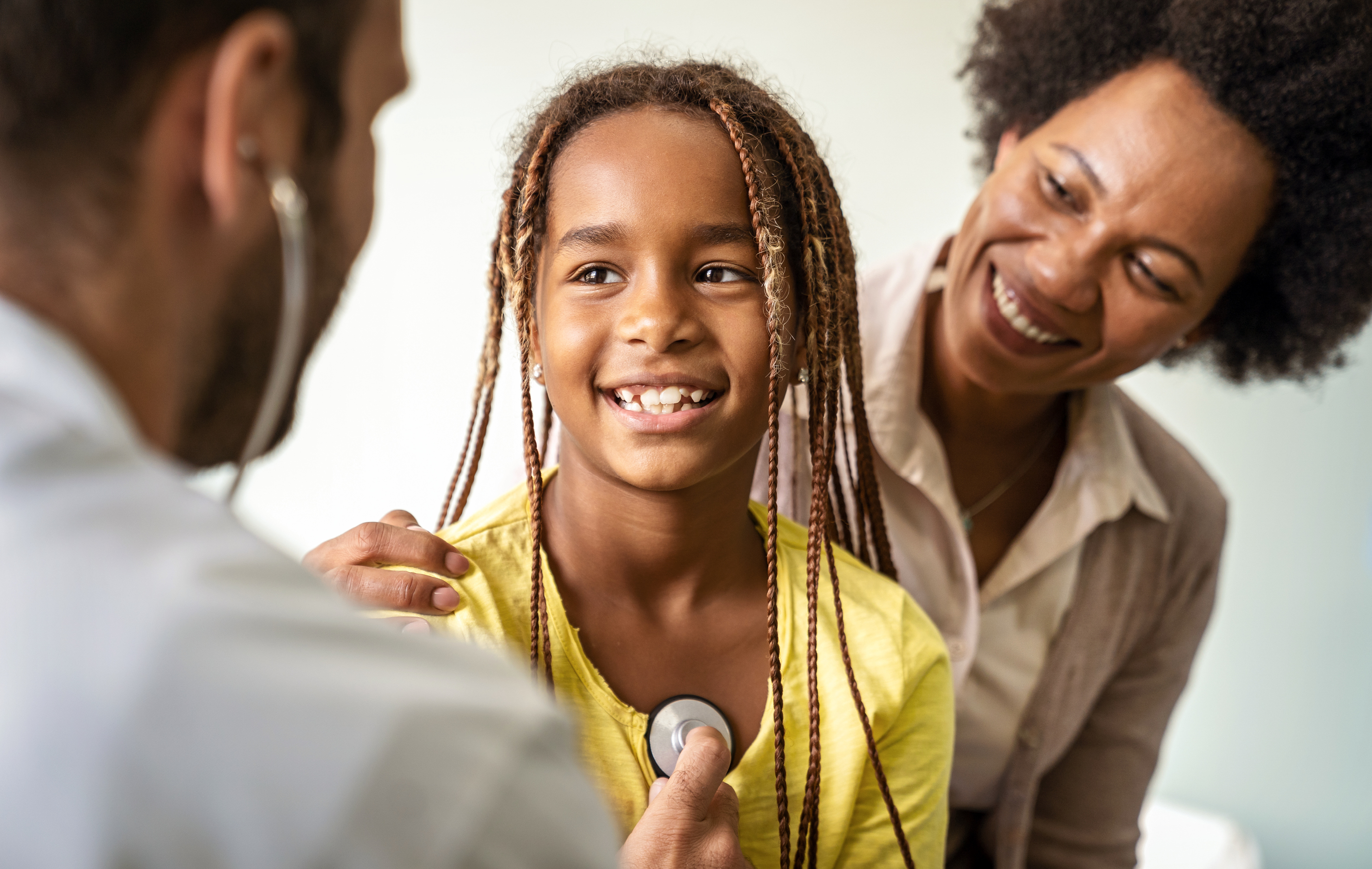 doctor checking listening to girl's heart