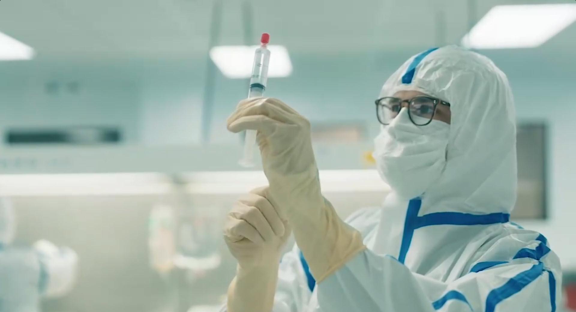 person in lab holding syringe