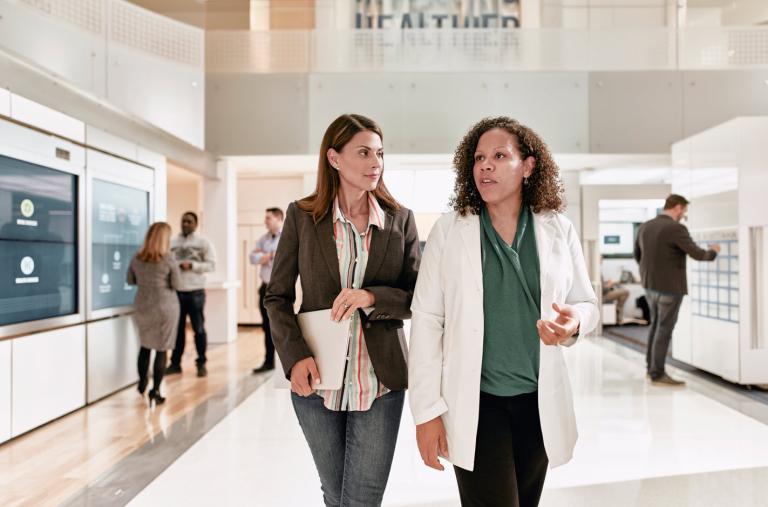 Client and Pharmacist walking next to each other. 