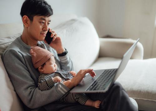 Man and baby with laptop and phone.